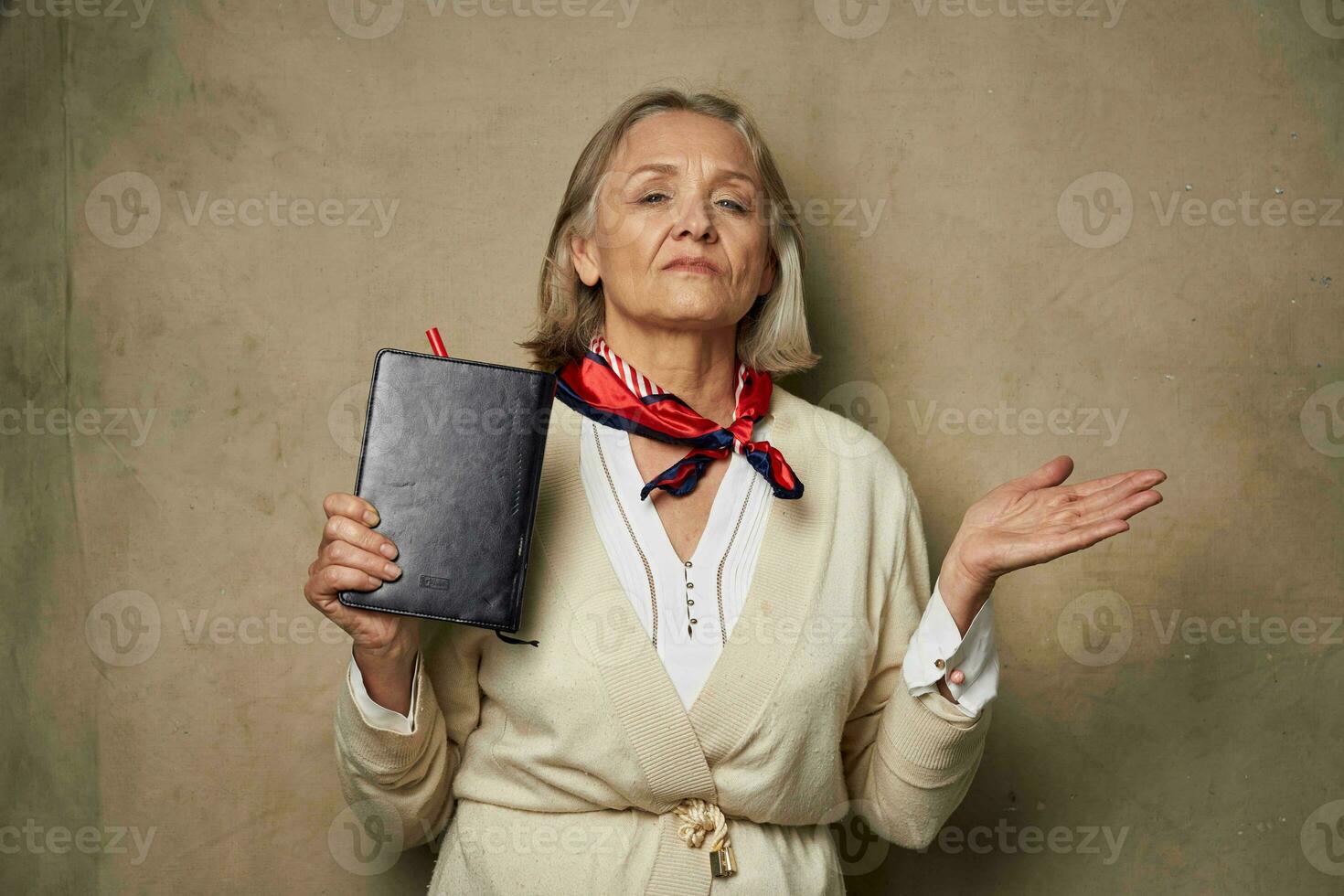 personnes âgées femme dans une pansement robe avec une carnet dans sa mains studio travail photo