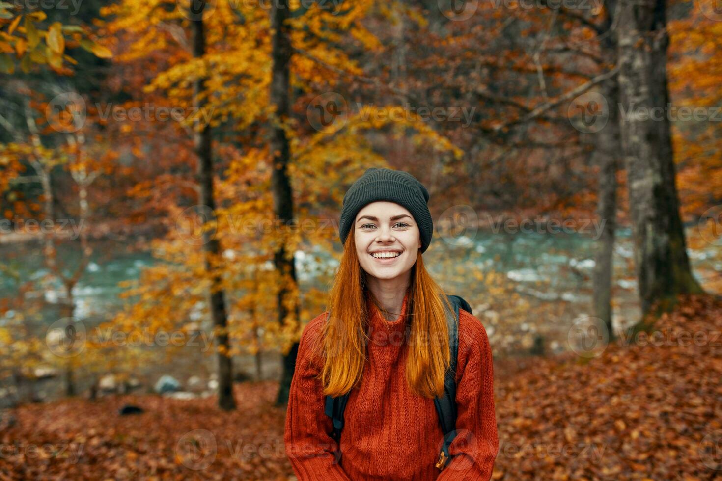 de bonne humeur femme voyages dans le l'automne forêt dans la nature près le rivière et grand des arbres dans le Contexte photo