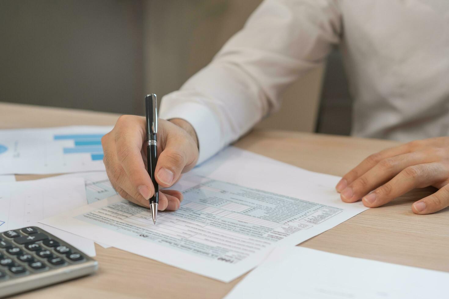 proche en haut main de stress asiatique Jeune employé affaires homme, Masculin calculer impôt le revenu et dépenses, factures, crédit carte pour Paiement ou jour de paie sur table à Accueil bureau. financier, la finance gens concept. photo