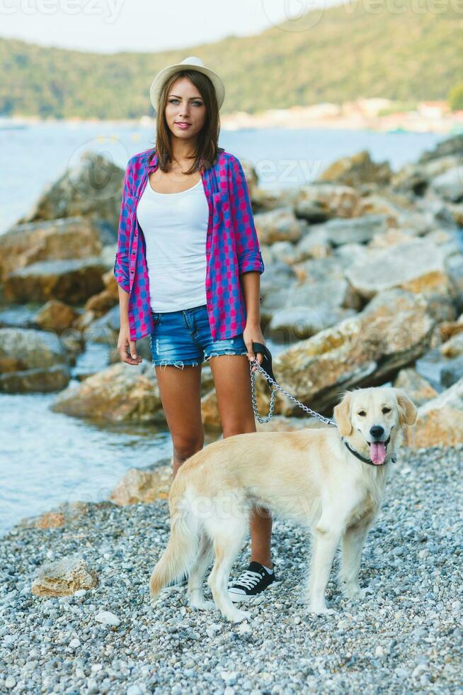 femme avec une chien sur une marcher sur le plage photo