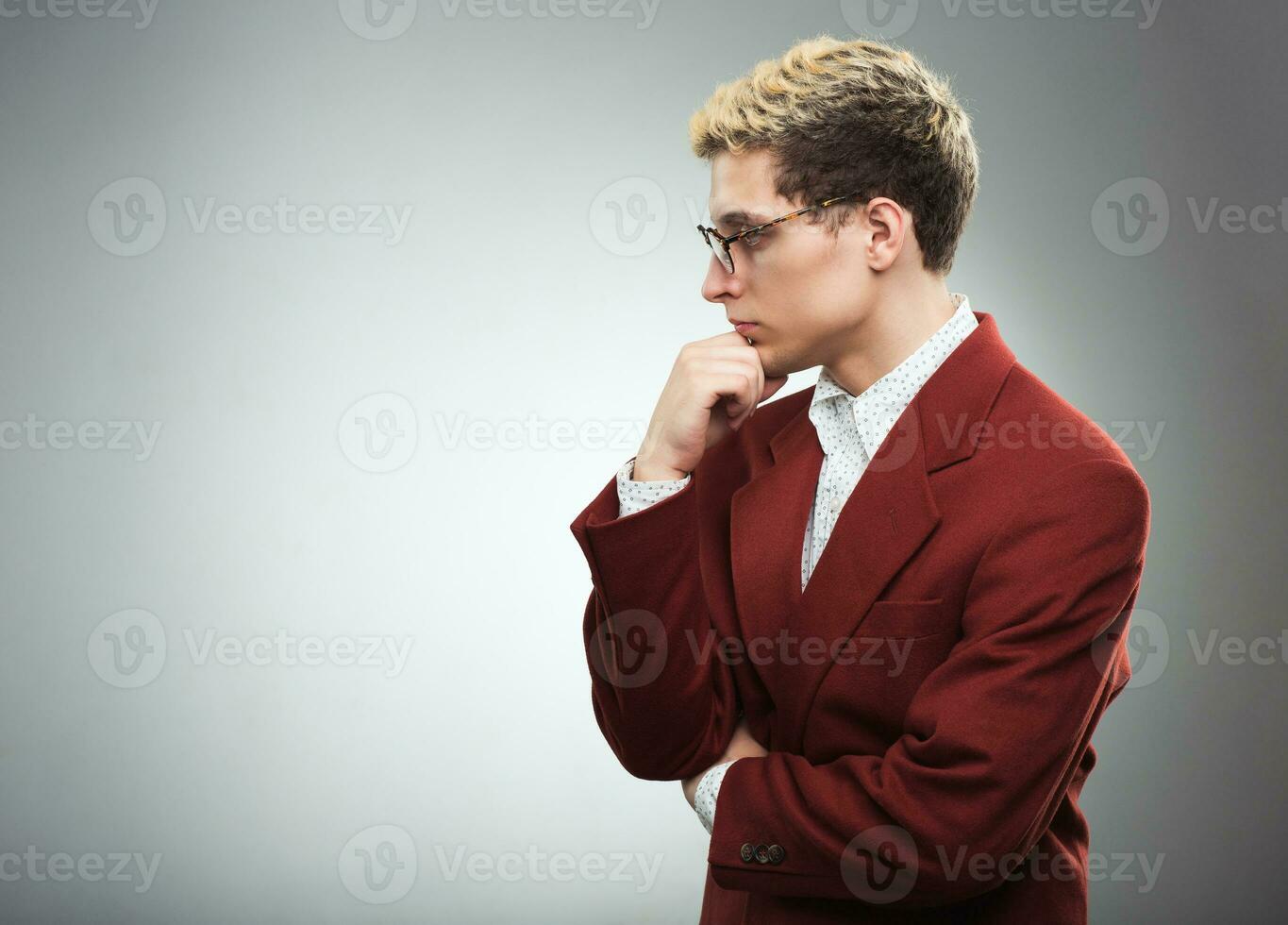 Jeune homme avec des lunettes en pensant photo