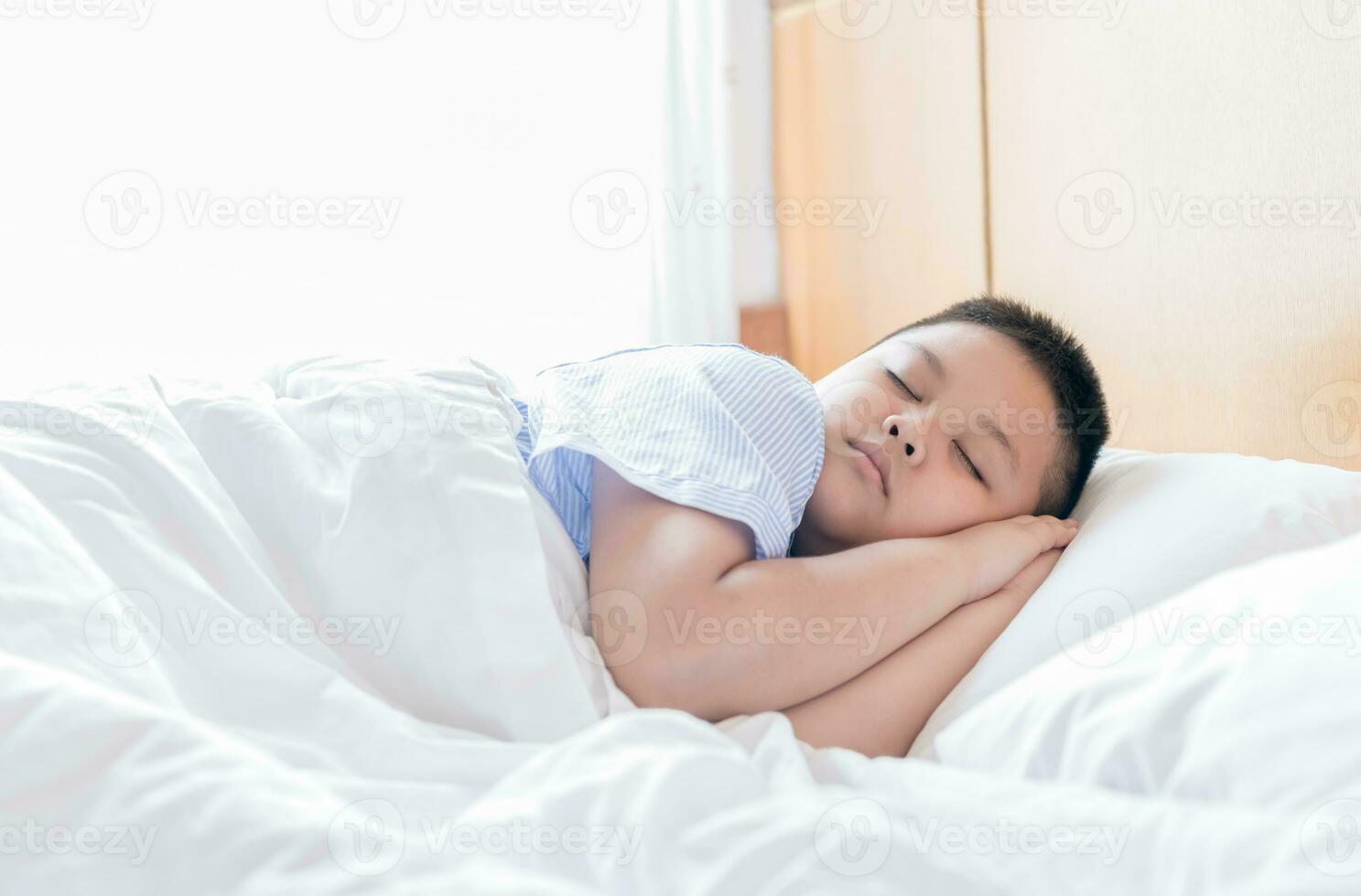 obèse graisse garçon sommeil sur lit dans Matin photo