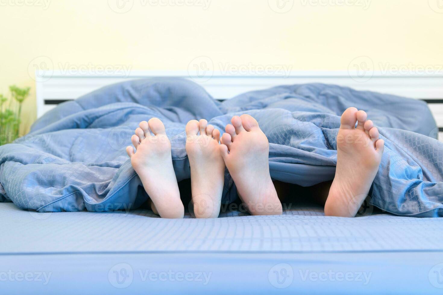 deux paires de pieds de enfants. frère et sœur mensonge en dessous de couverture photo