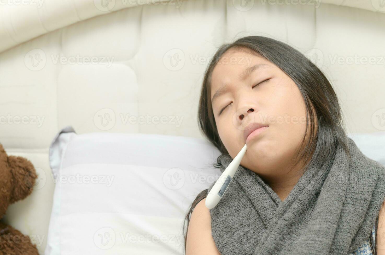 malade fille avec thermomètre dans bouche photo