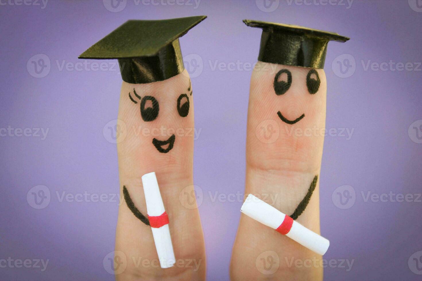 visage peint sur le des doigts. élèves en portant leur diplôme photo