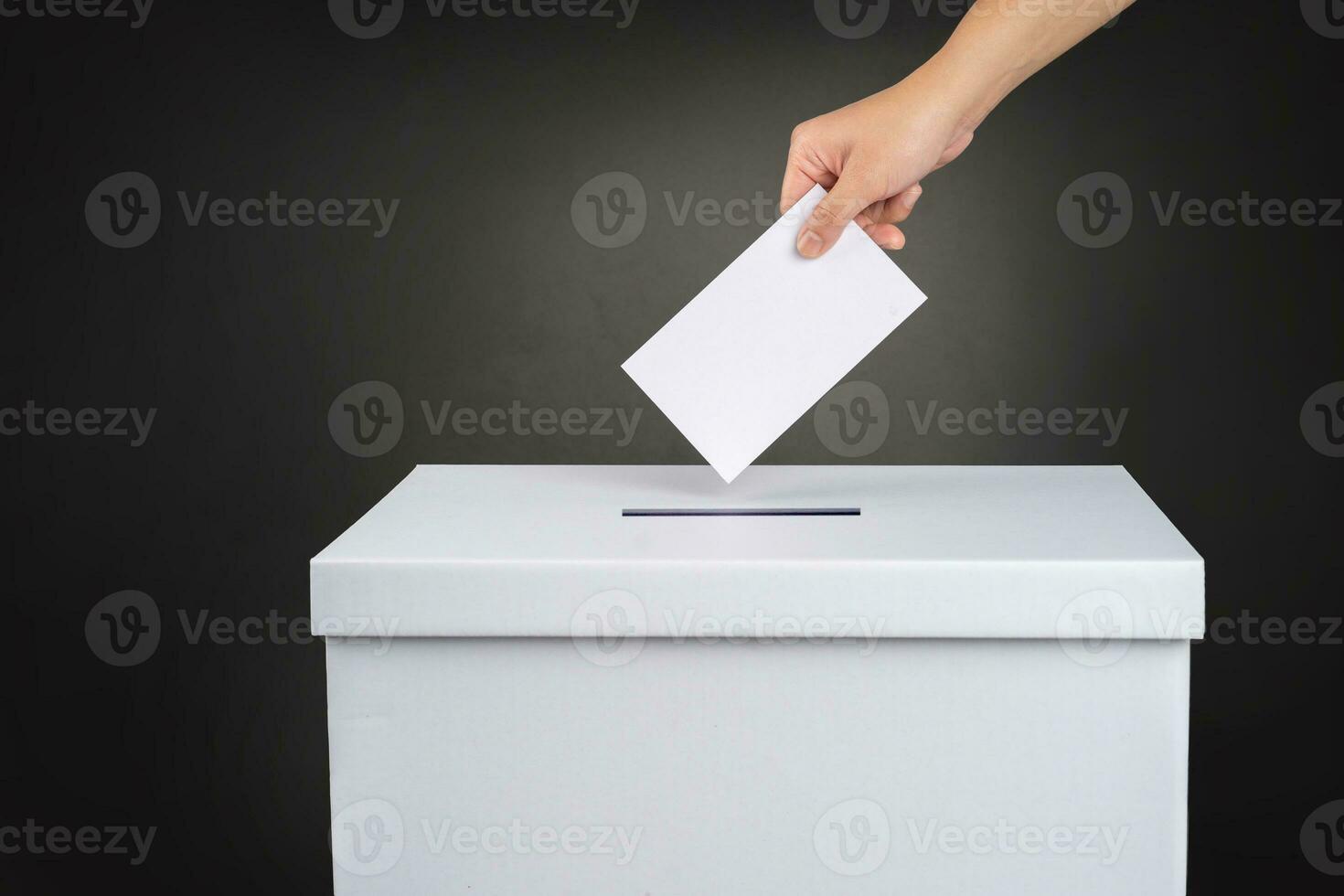 le électeur détient le sien voter scrutin papier et des endroits il dans le scrutin boîte. élection concept. photo