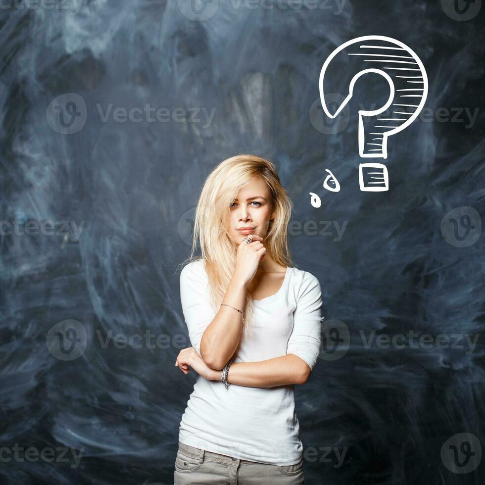 magnifique blond femme avec question marque sur tableau noir photo