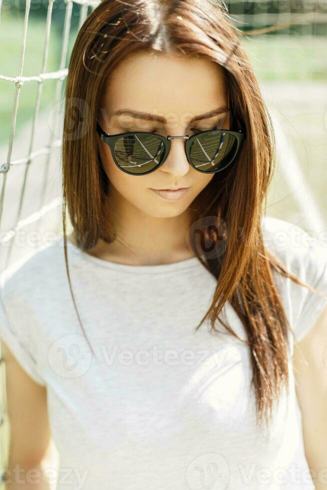 portrait de une magnifique fille dans des lunettes de soleil sur une été ensoleillé journée. photo