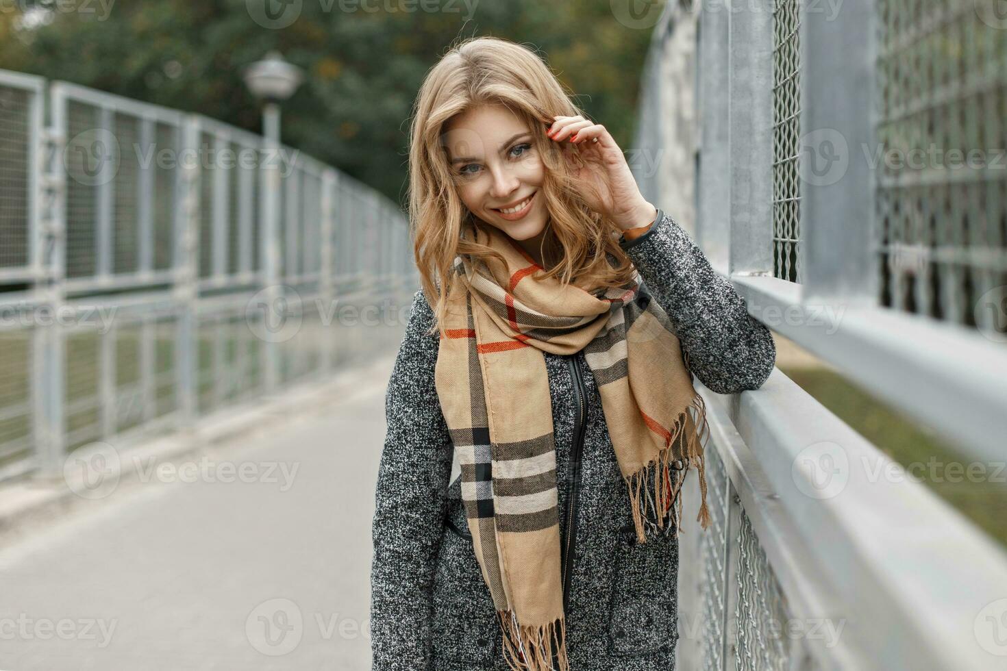 magnifique Jeune fille avec une sourire dans une chaud écharpe et manteau dans l'automne journée. photo