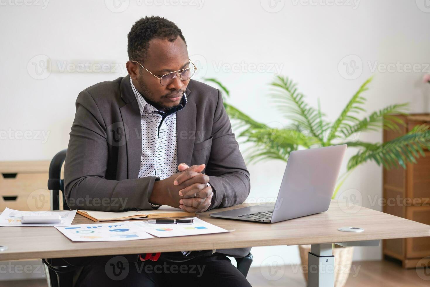 africain américain homme d'affaire en cours d'analyse portable graphique formalités administratives dans Bureau en portant les documents en train de préparer portefeuille une analyse rapport noir Masculin analyste Faire formalités administratives dans le lieu de travail en utilisant le ordinateur. photo