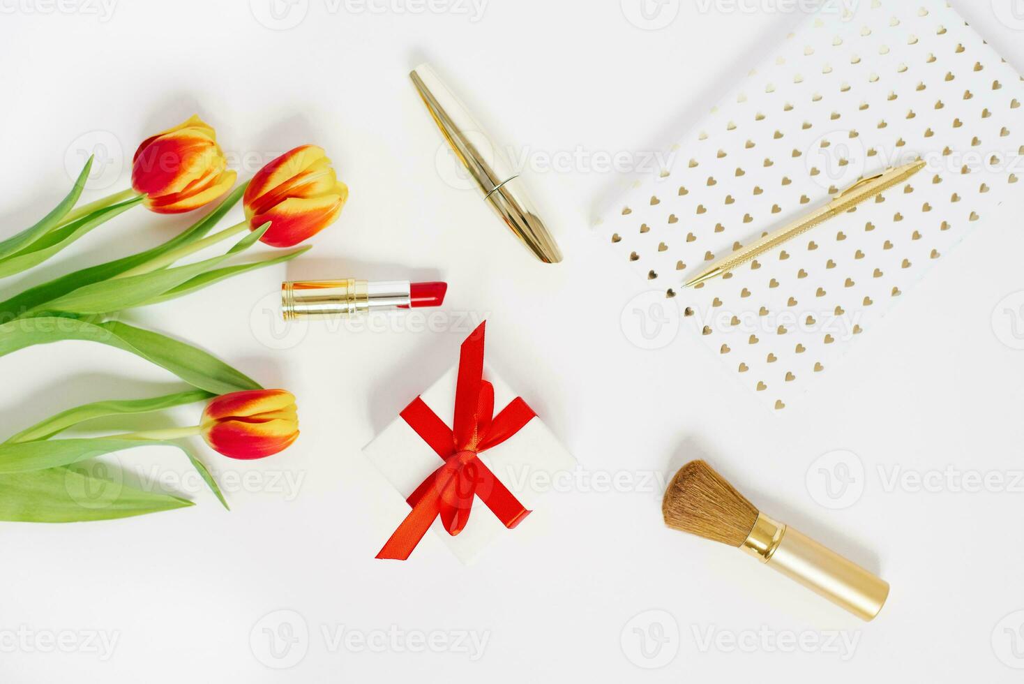 carte postale pour la Saint-Valentin jour, de la mère journée ou Mars 8. une bouquet de tulipes, une cadeau avec une rouge arc, produits de beauté et une carnet avec une stylo. falt allonger blogueur photo