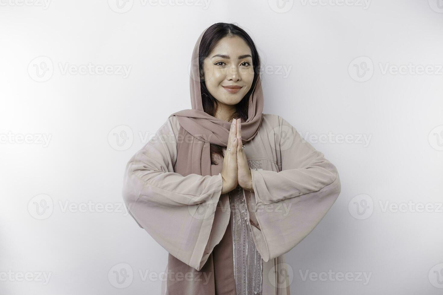 portrait de une Jeune magnifique asiatique musulman femme portant une foulard faire des gestes eid mubarak salutation photo