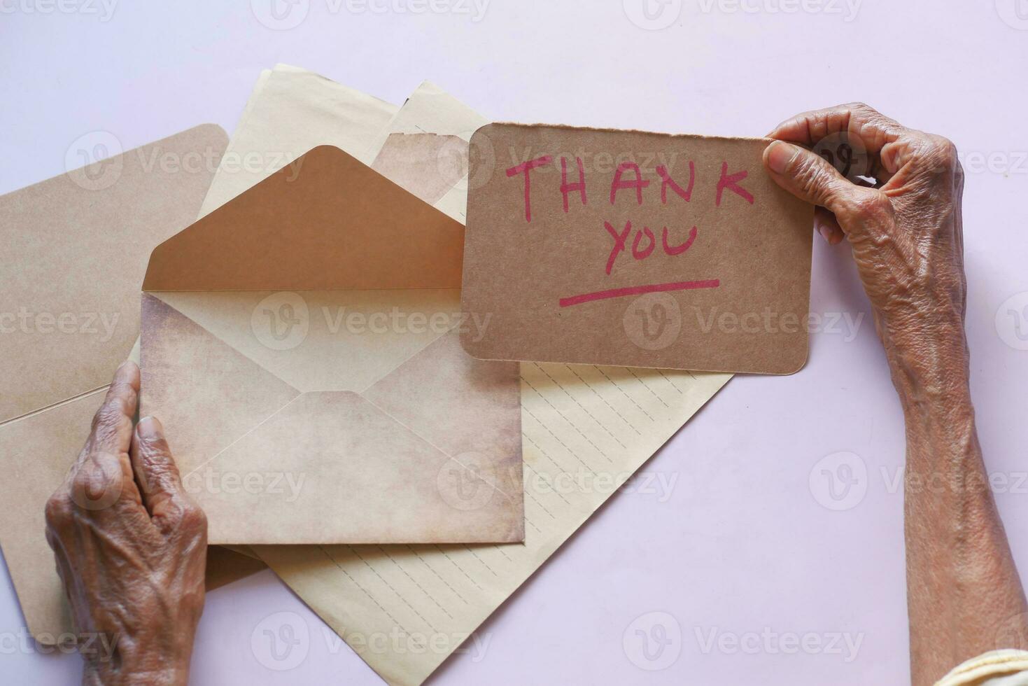 main de femme âgée tenant une lettre de remerciement, vue arrière photo