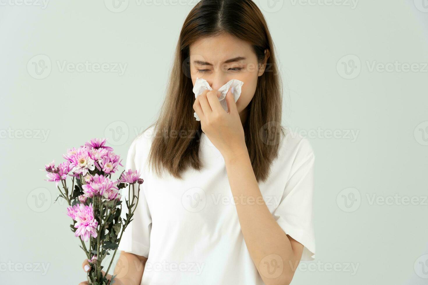 pollen allergiques, asiatique Jeune femme éternuements dans une mouchoir ou soufflant dans une essuyer, allergique à sauvage printemps fleurs ou fleurs pendant printemps. allergique réaction, respiratoire système problèmes photo