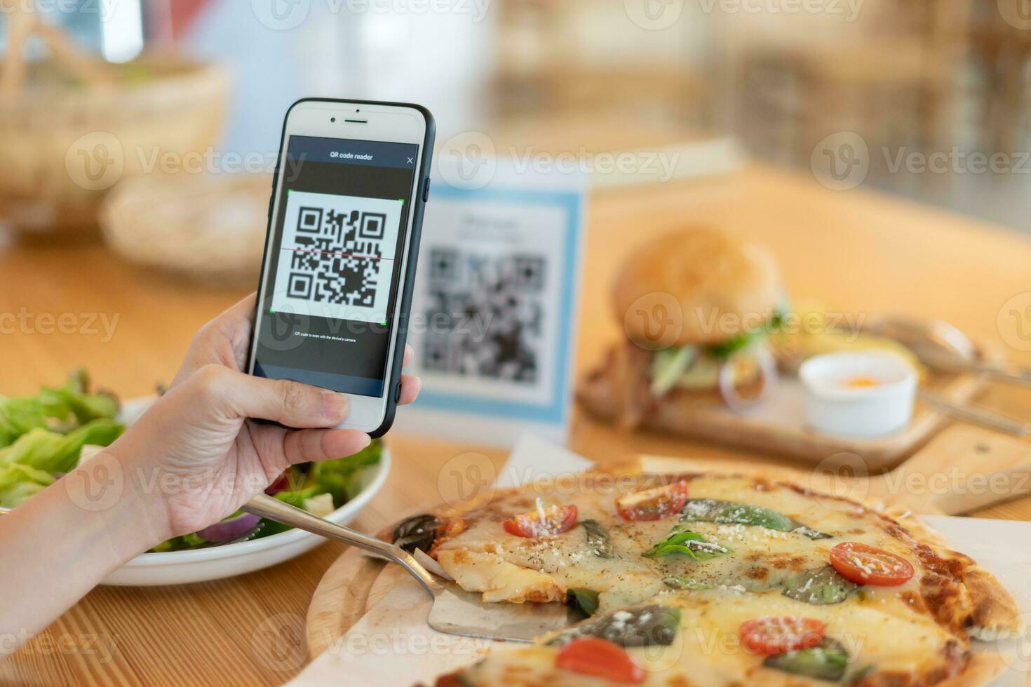 une femme utilise un smartphone pour scanner le code qr pour payer au café-restaurant avec un paiement numérique sans espèces. choisissez le menu et commandez accumulez la remise. portefeuille électronique, technologie, paiement en ligne, carte de crédit, application bancaire. photo