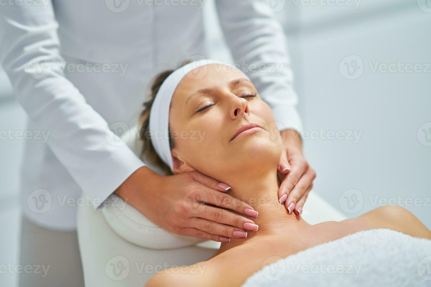 jeune femme agréable ayant un massage du visage au spa photo