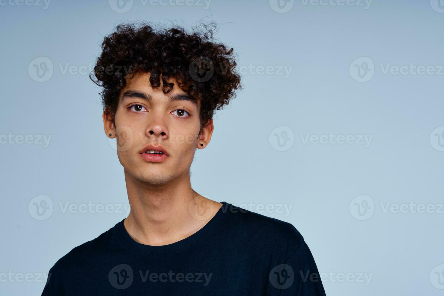 homme avec frisé cheveux dans noir T-shirt tondu vue isolé Contexte photo