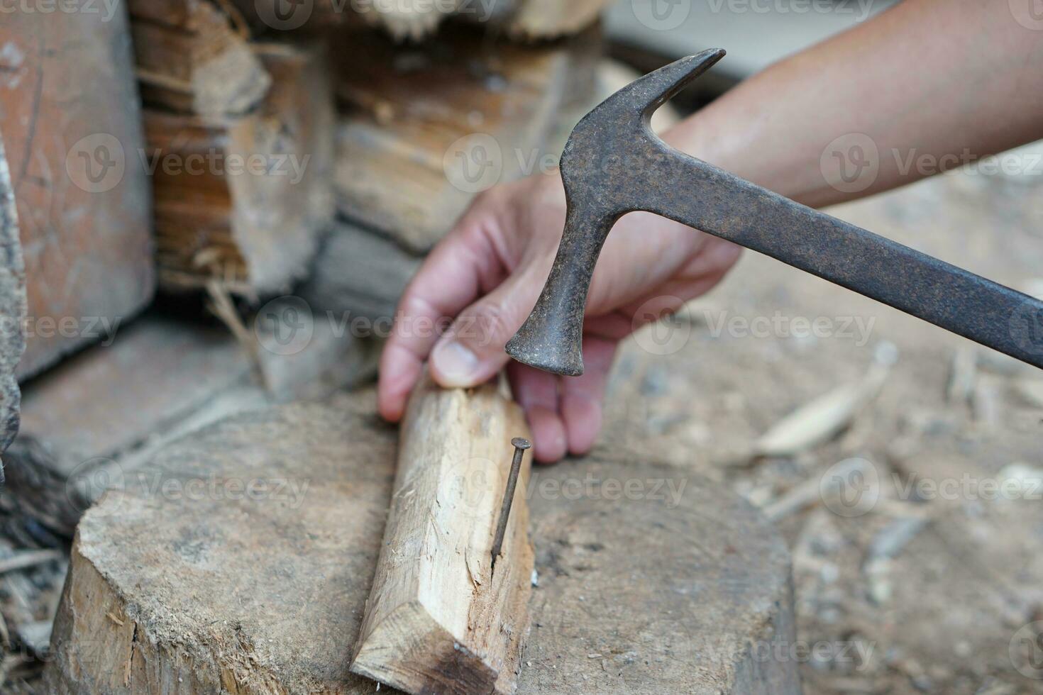 fermer Charpentier utilisation vieux marteau à frappé métal clou sur bois. concept, charpenterie et construction outils. réparation ou fixation, DIY boiseries. local mode de vie. photo