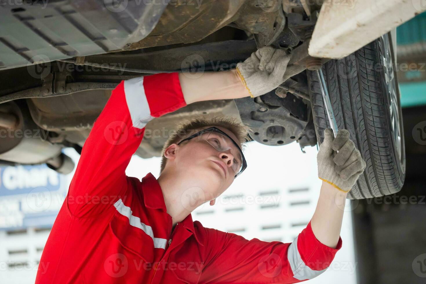 auto mécanicien travail dans garage, technicien homme travail dans auto un service avec levé véhicule, voiture réparation, et entretien photo