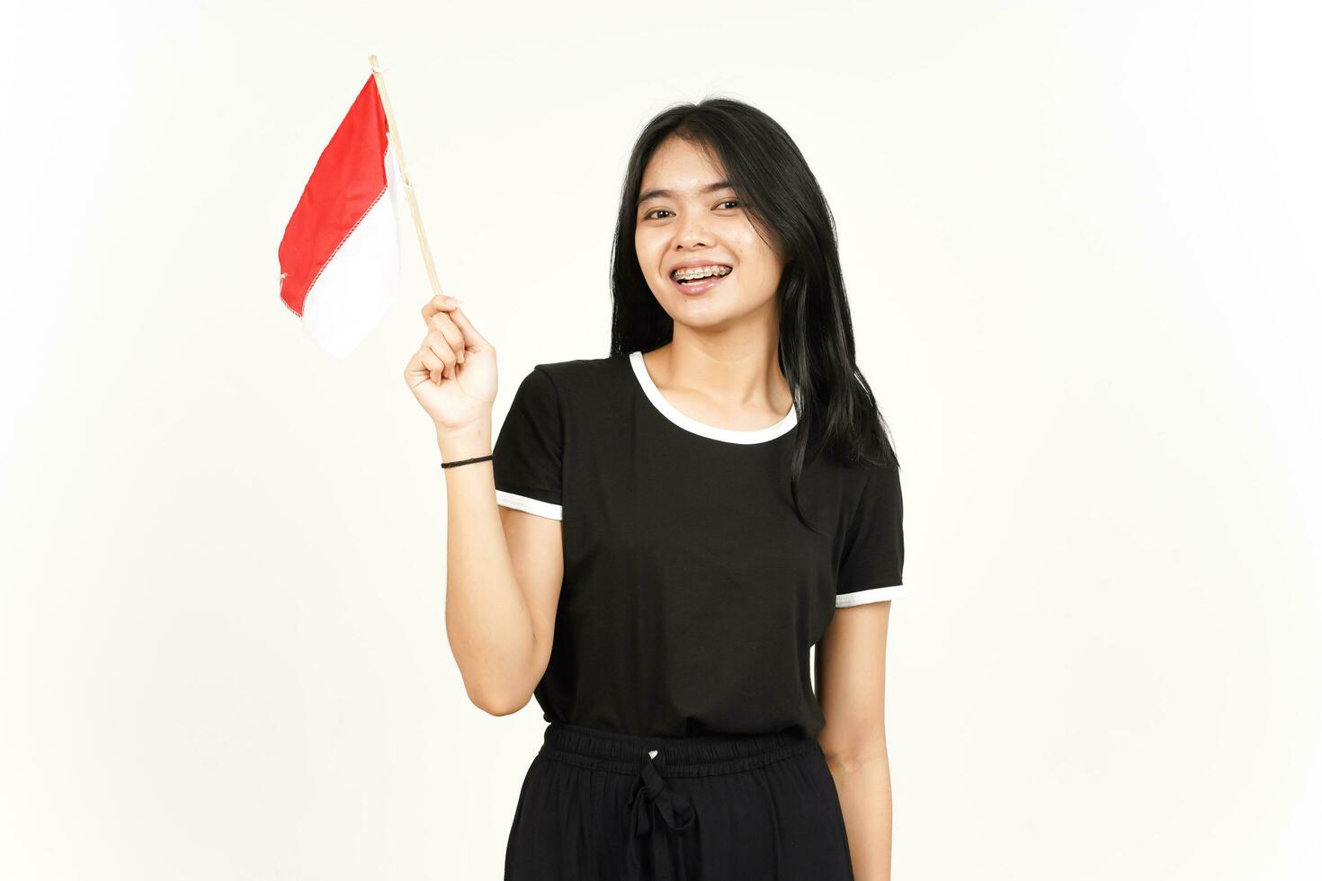 souriant et tenant le drapeau indonésien de la belle femme asiatique isolée sur fond blanc photo