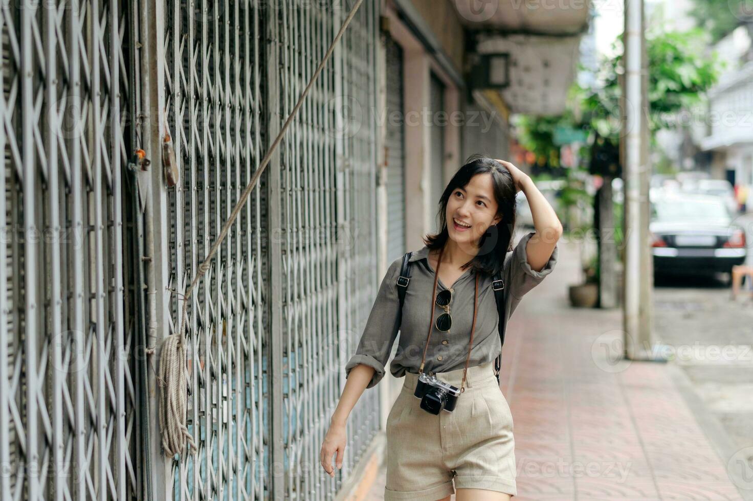 Jeune asiatique femme sac à dos voyageur profiter rue culturel local endroit et sourire. voyageur vérification en dehors côté des rues. photo