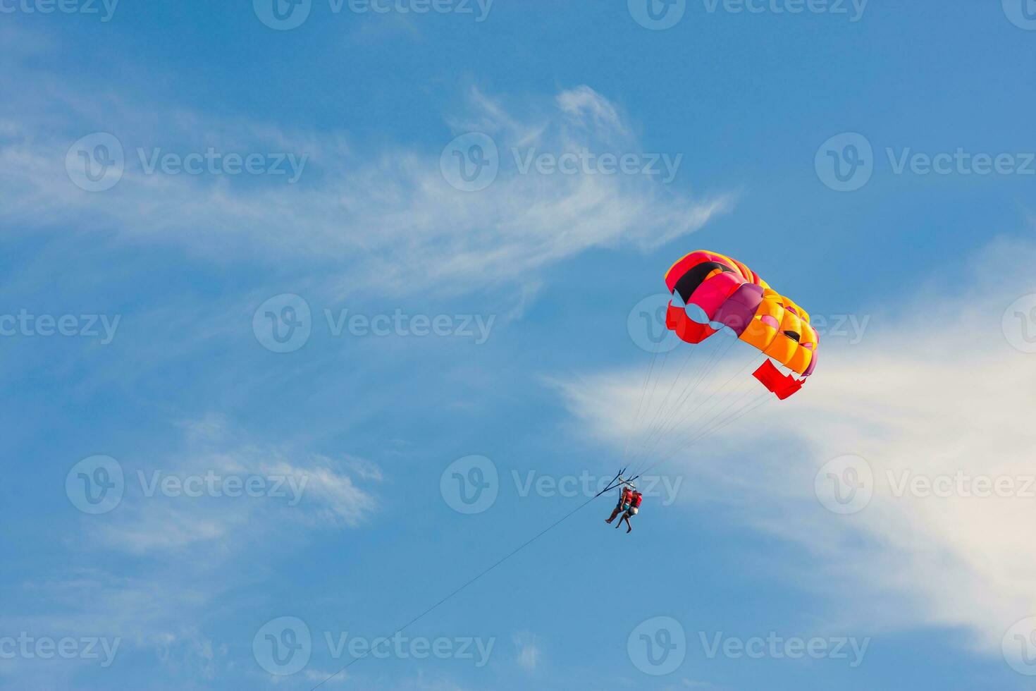 parachutistes mouche dans le bleu ciel avec une coloré parachute photo