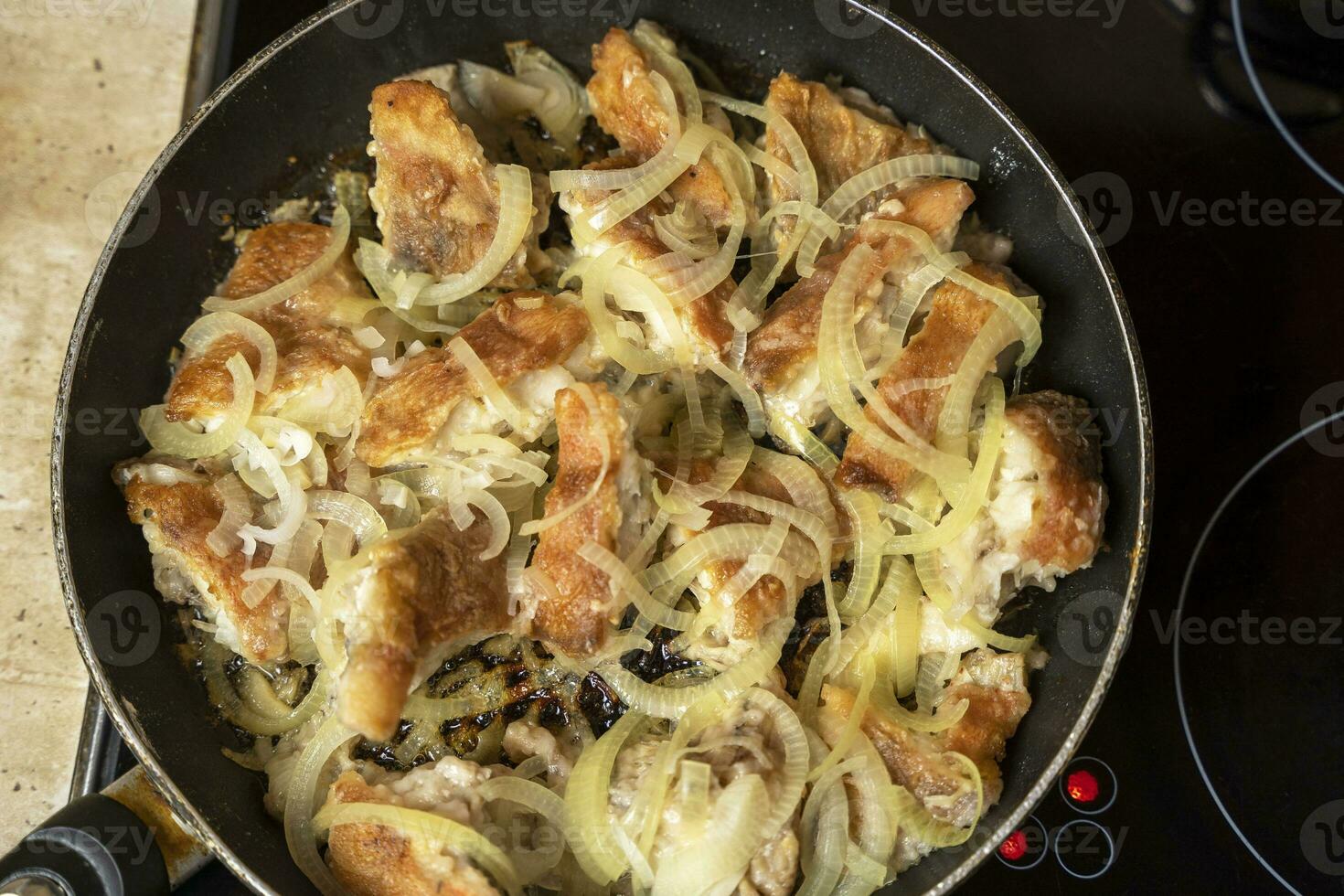 délicieux frit mer basse avec d'or oignon anneaux dans une friture poêle. Haut vue photo