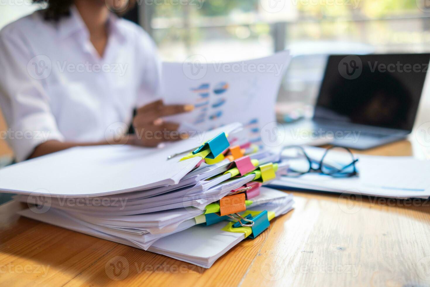 femme d'affaires mains travail sur piles de papier les documents à chercher et la revue les documents empilé sur table avant Envoi en cours leur à planche de réalisateurs à utilisation correct les documents dans réunion avec homme d'affaire photo