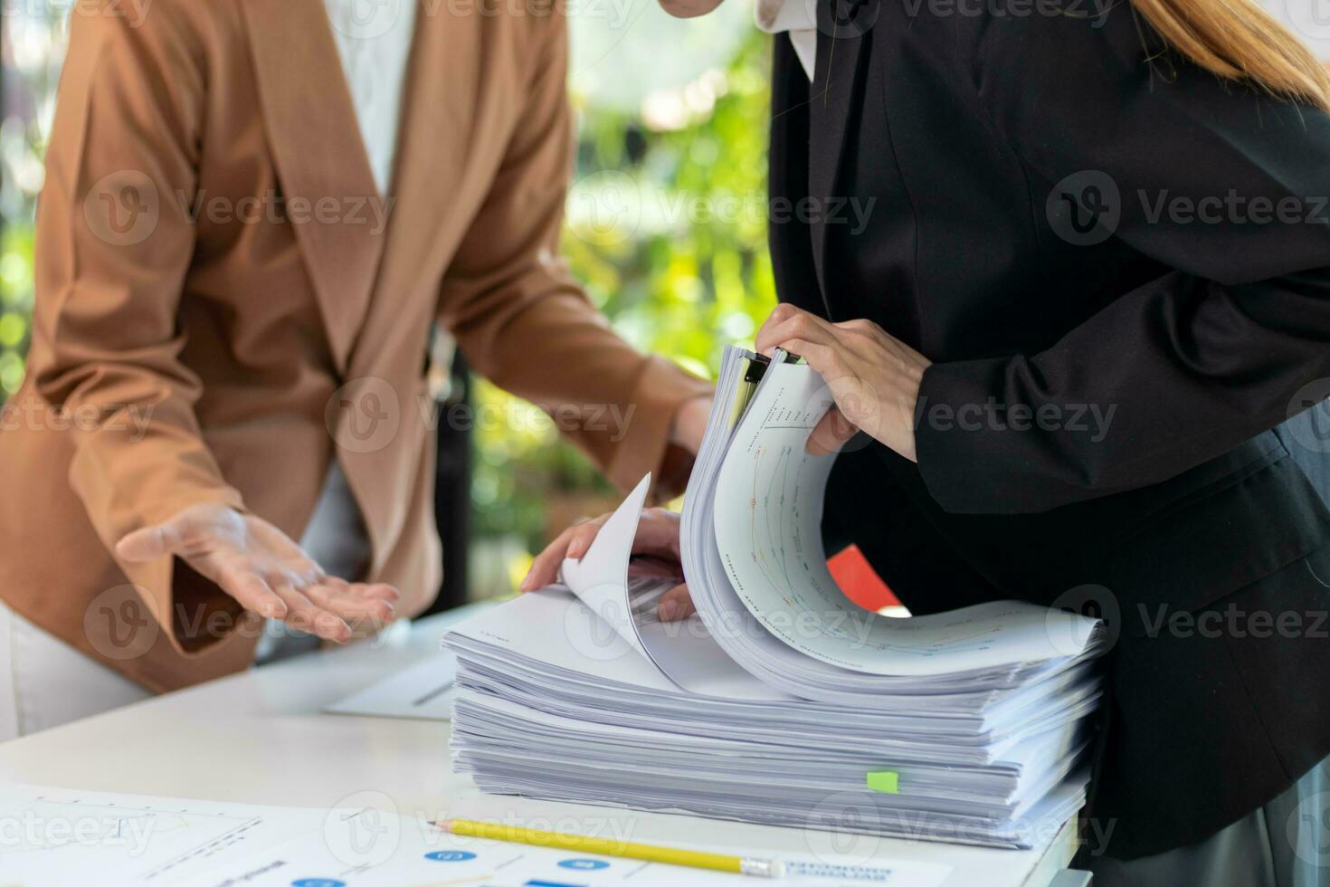 femme d'affaires mains travail sur piles de papier les documents à chercher et la revue les documents empilé sur table avant Envoi en cours leur à planche de réalisateurs à utilisation correct les documents dans réunion avec homme d'affaire photo