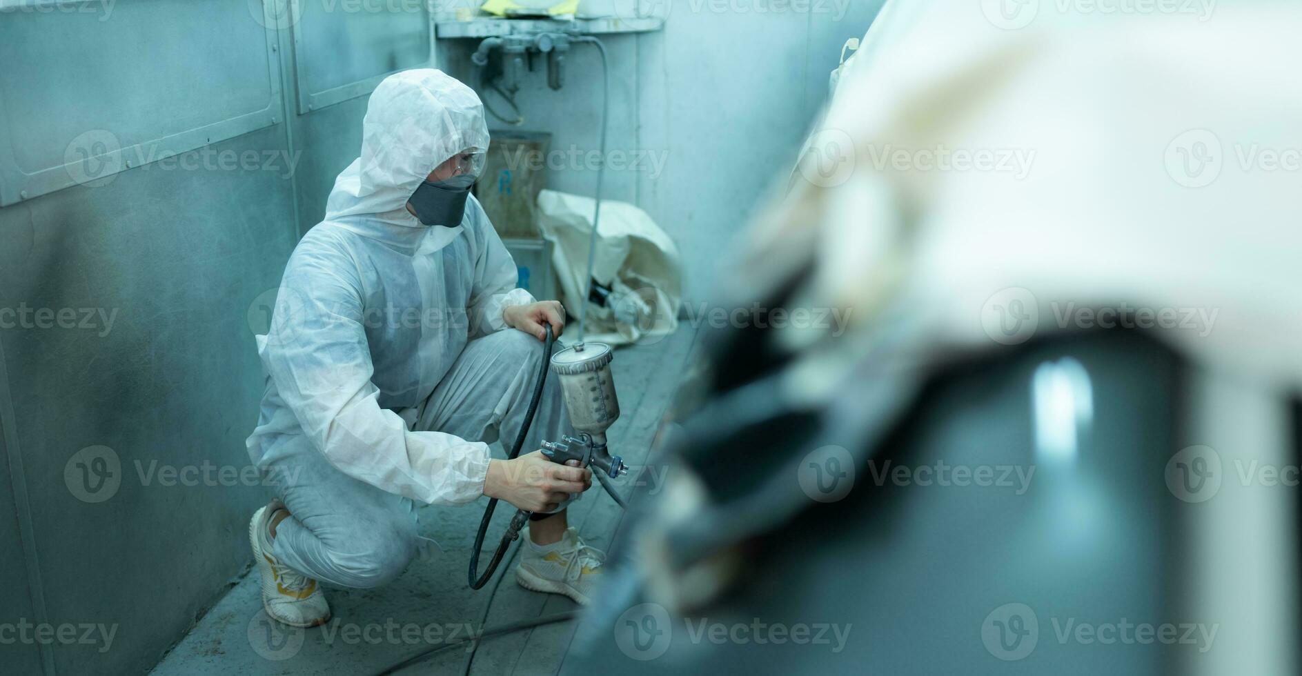 auto mécanicien dans voiture vaporisateur pièce utilisation une vaporisateur buse injecté à le côté de le voiture corps avec se soucier à créer beauté cette mélanges avec le original Couleur de le auto. photo