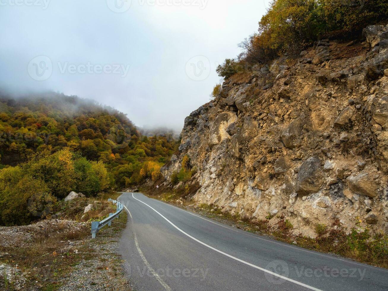 vide Matin Autoroute par le passer dans épais brouillard. magnifique asphalte autoroute, autoroute, Autoroute par de caucasien paysage montagnes collines à du froid temps dans milieu octobre. ingouchie. photo