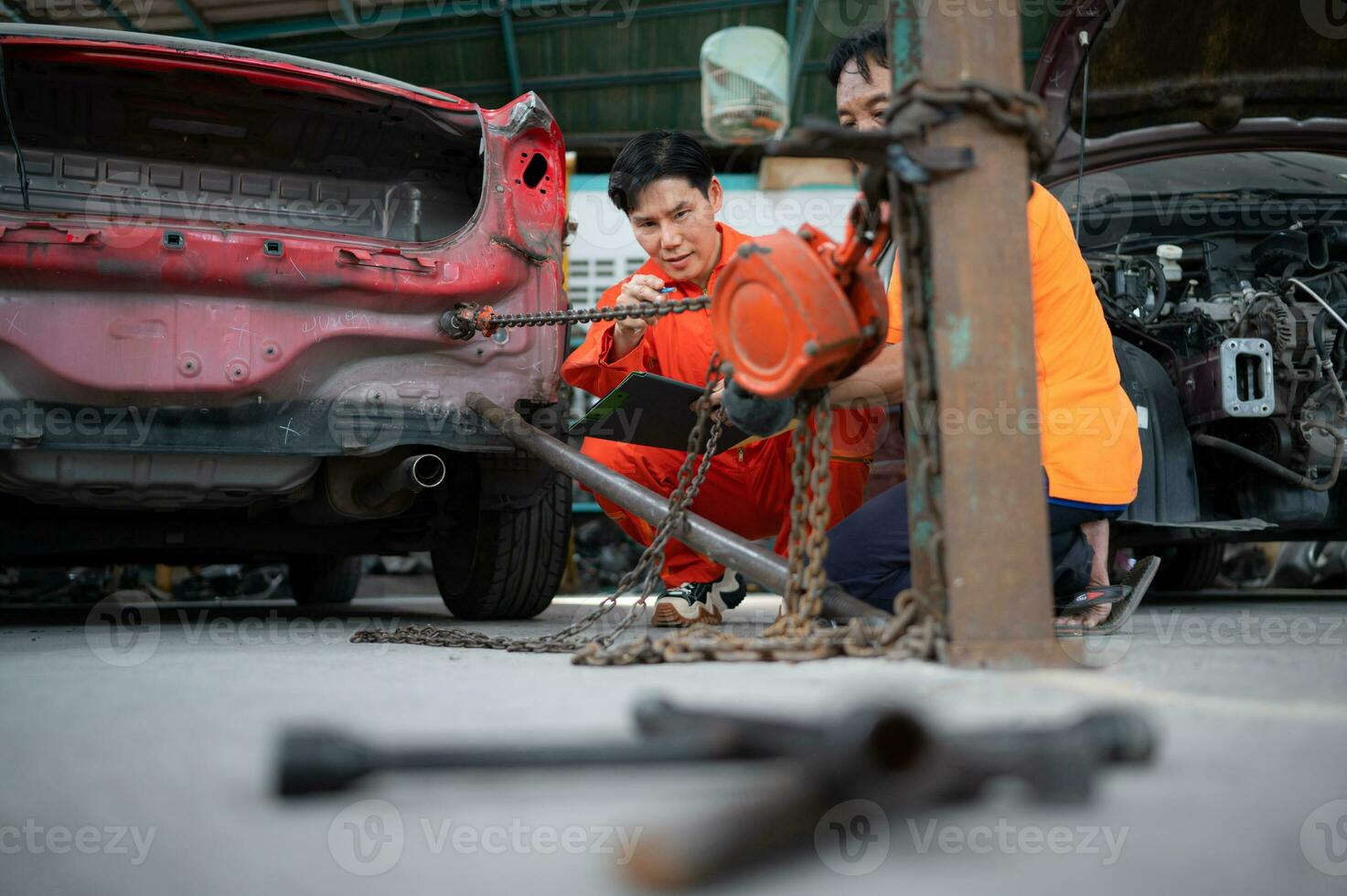 à revenir le voiture corps à ses ancien forme, un auto réparation mécanicien les usages une machine à tirer le voiture corps causé par une lourd collision jusqu'à ce que il est déformé. photo