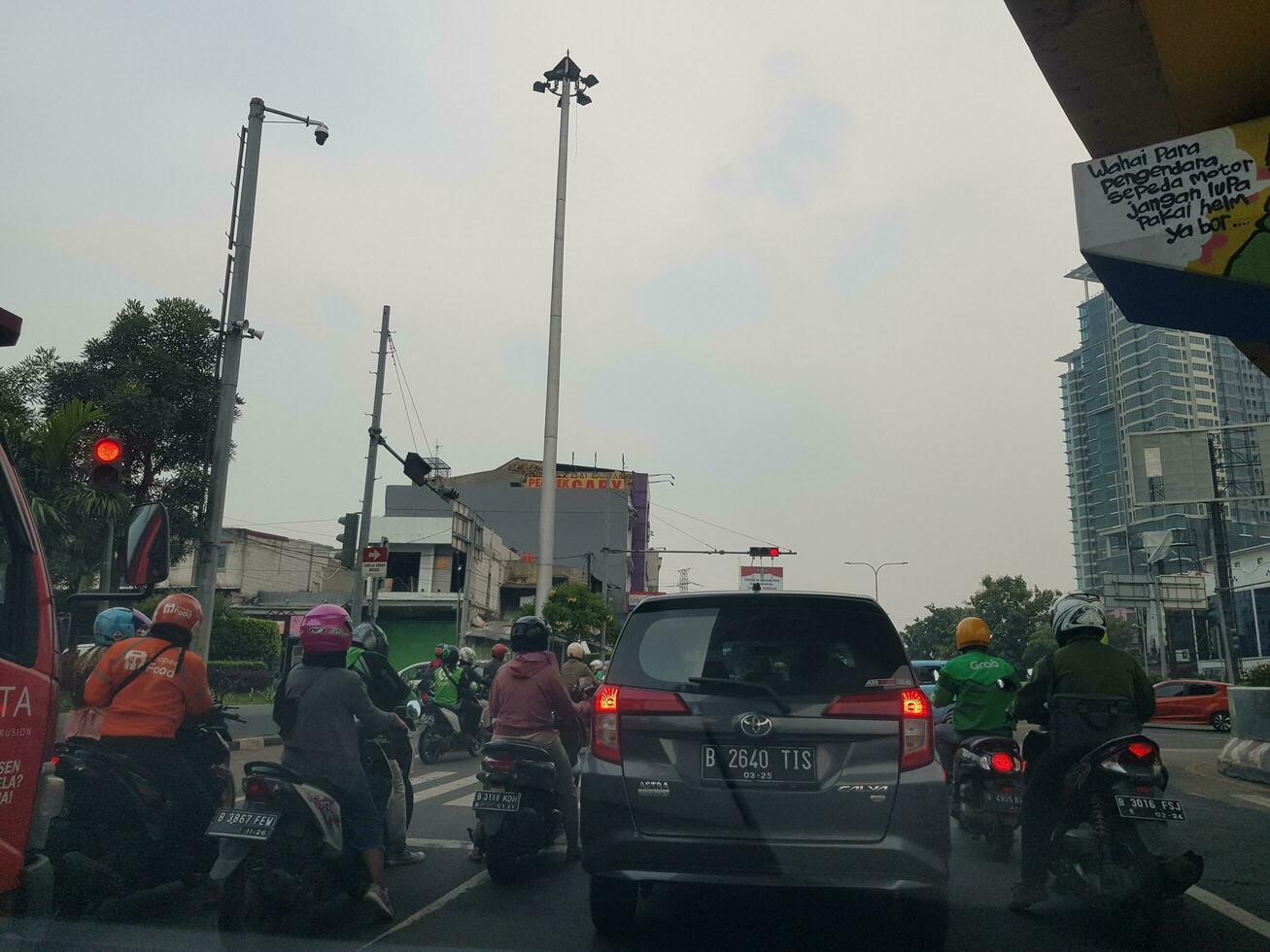 bekasi, Indonésie dans Mars 2019. nombreuses motocyclettes et voitures arrêté à le rouge lumière dans est bekasi en dessous de le survol vers narogong. photo