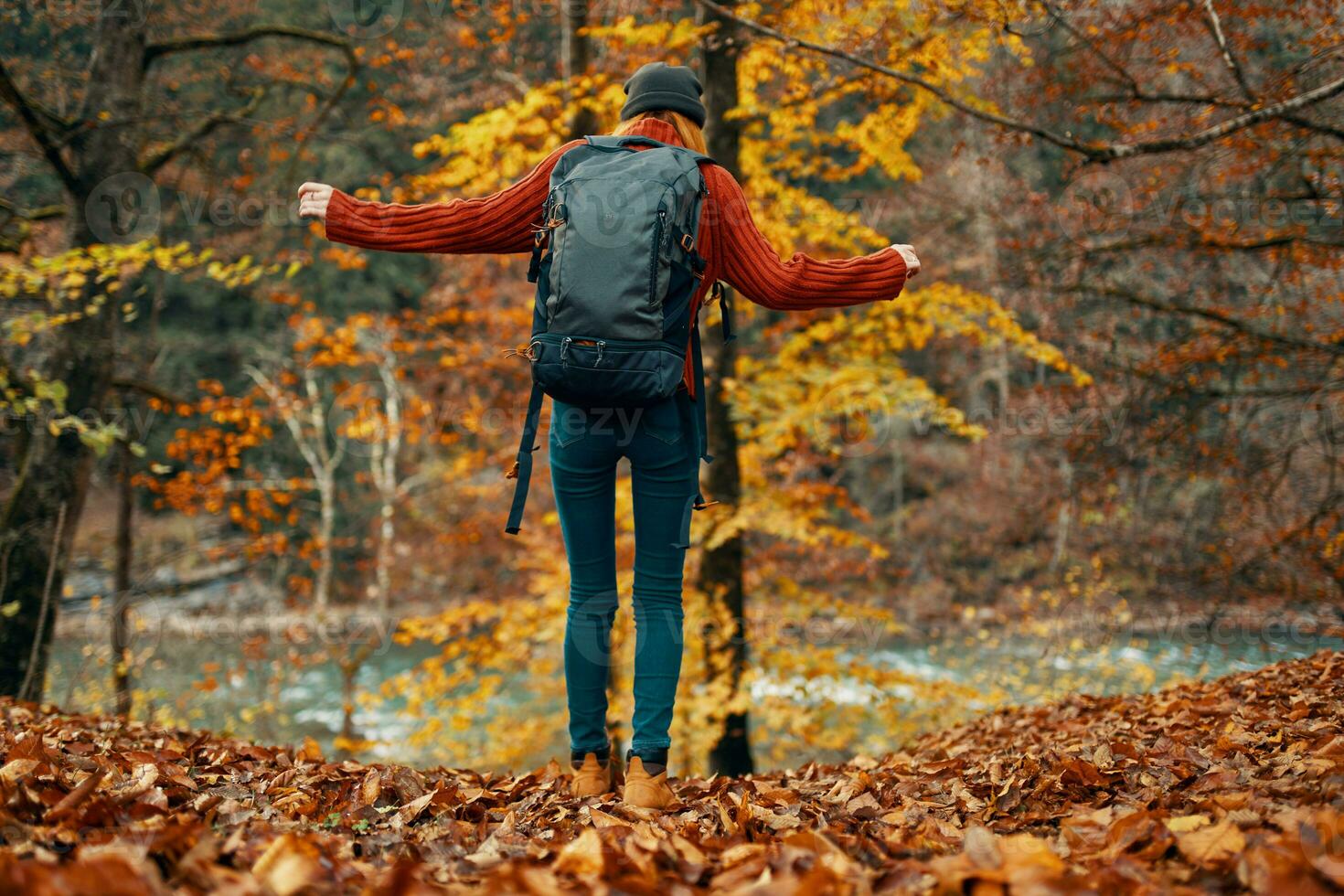 femme dans une chandail et jeans et bottes dans l'automne dans une parc dans la nature près le rivière photo