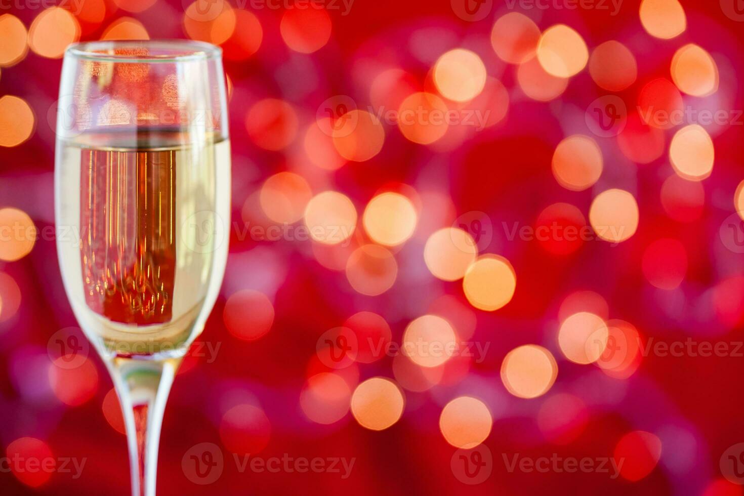 Champagne verre sur lumière bokeh rouge Contexte photo