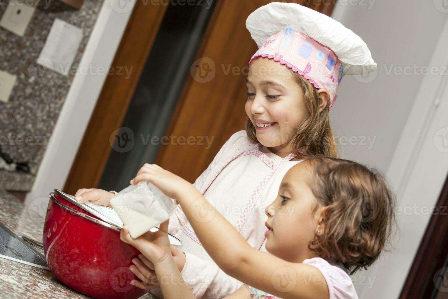 sœurs ayant amusement cuisson petits gâteaux ensemble à maison. photo