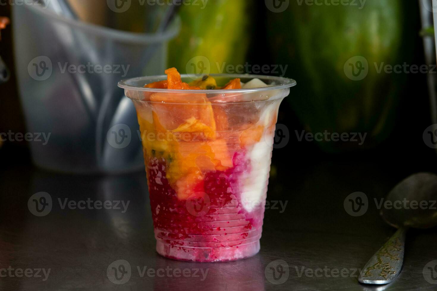 préparation de une traditionnel sucré l'eau la glace avec des fruits appelé cholado dans le ville de cali dans Colombie photo