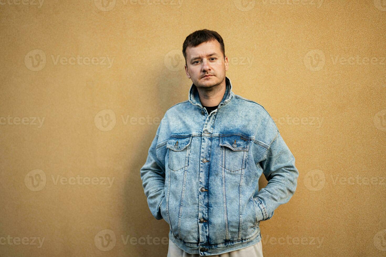 portrait de élégant homme dans jeans veste contre Jaune mur. photo