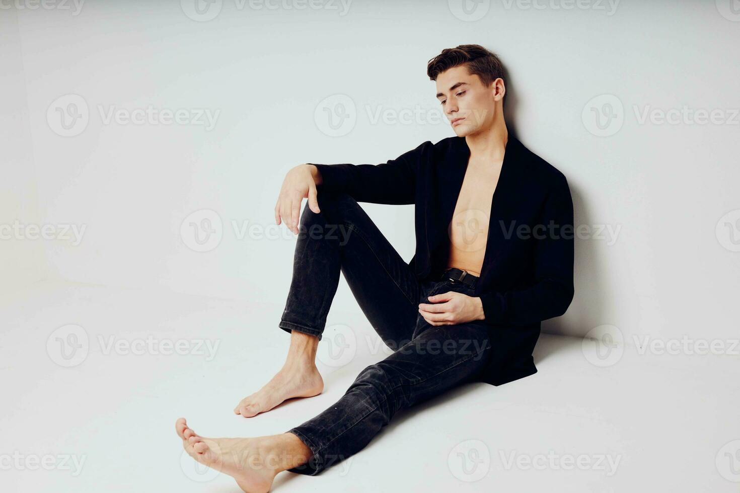 homme séance sur le sol portant noir veste mode élégant vêtements studio mode de vie photo