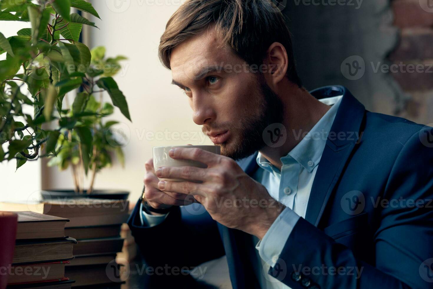 une homme dans une costume les boissons café près le fenêtre de une café. photo