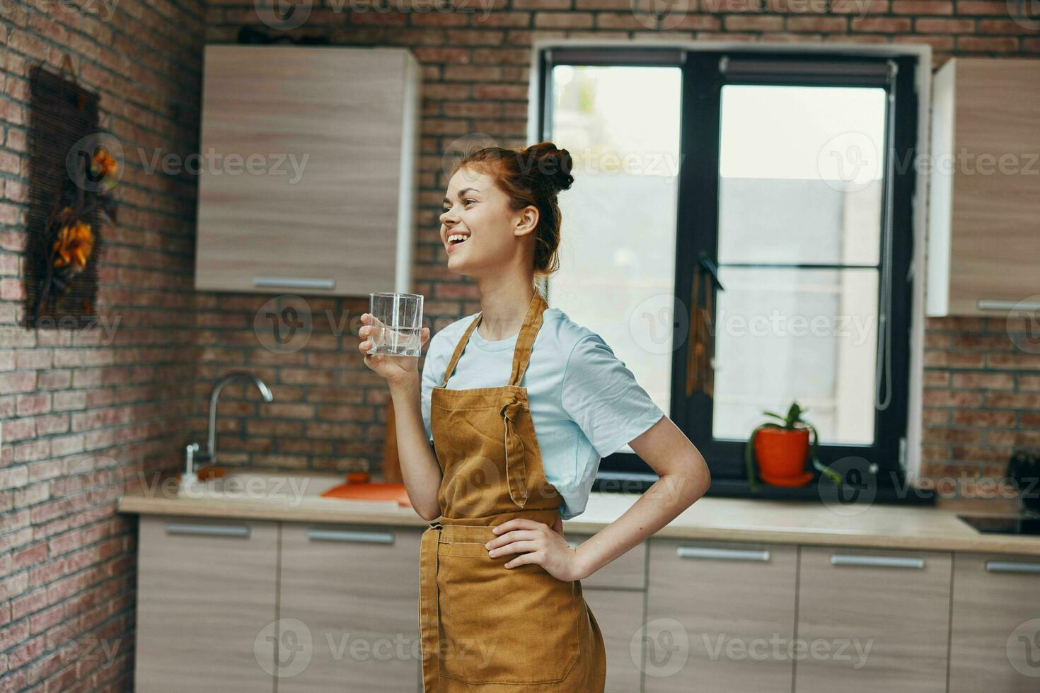 magnifique femme dans une marron tablier cuisine intérieur moderne style  verre de l'eau 23668146 Photo de stock chez Vecteezy