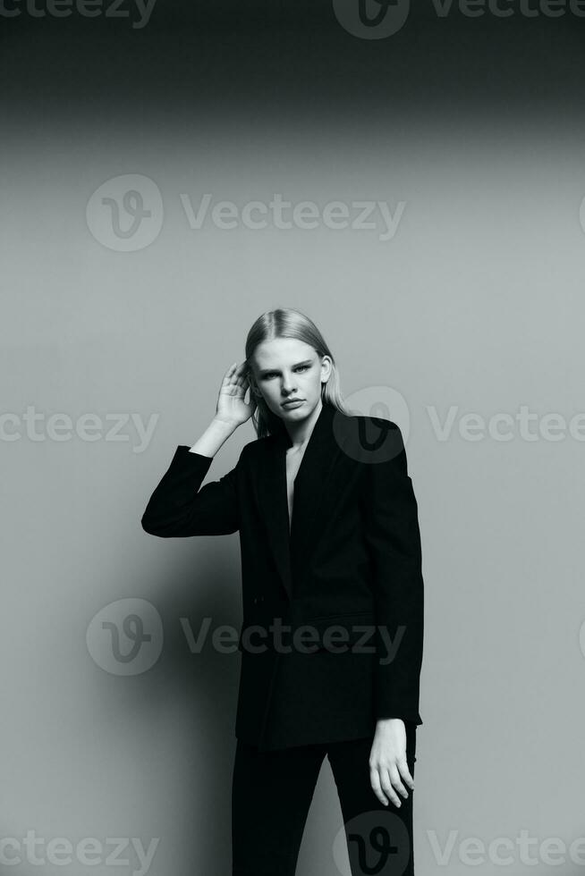 une Jeune élégant fille dans une veste pose dans une noir et blanc studio. une concept pour Vêtements marques. cool offre bannière pour vente photo