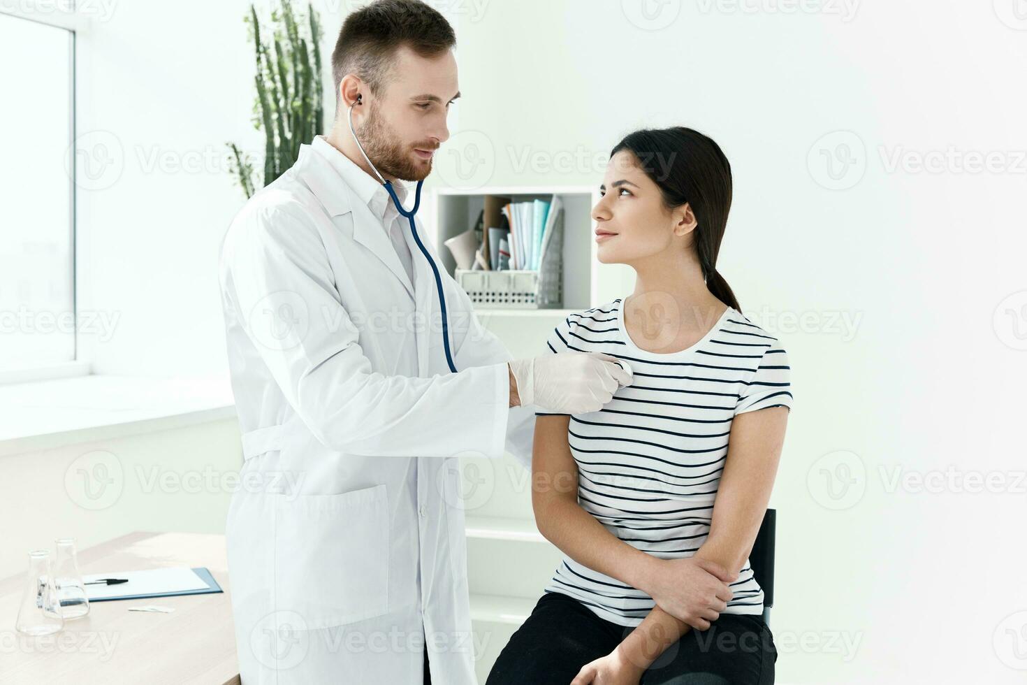 une médecin avec une stéthoscope examine une patient dans une hôpital photo