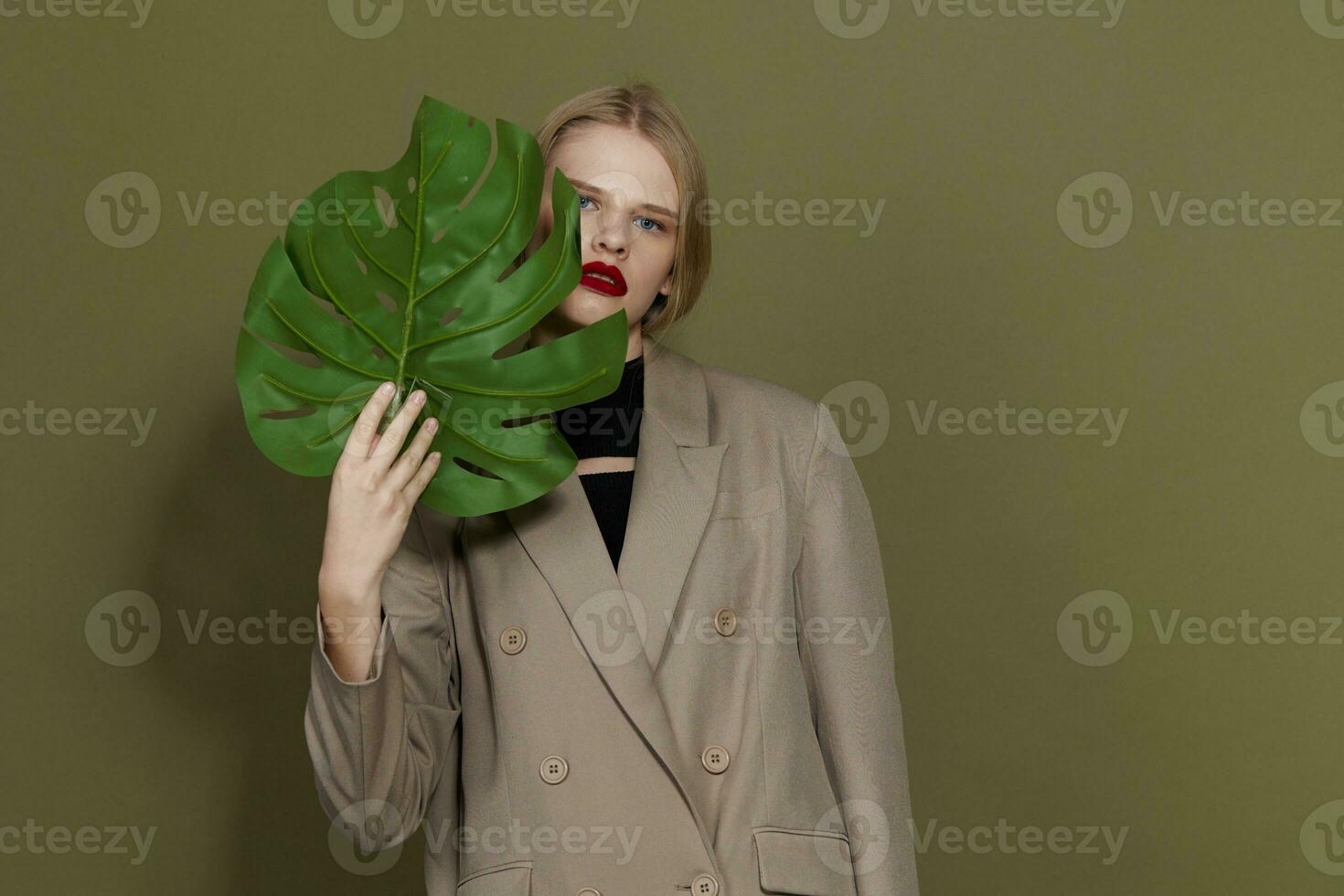 glamour femme dans manteau rouge lèvres mode paume feuille studio modèle inchangé photo