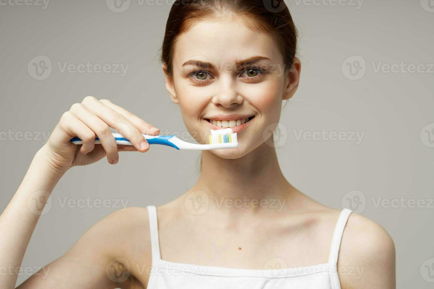 jolie femme dans blanc T-shirt dentaire hygiène santé se soucier studio mode de vie photo