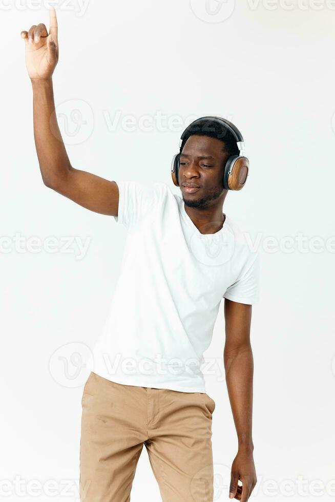 de bonne humeur homme de africain apparence dans écouteurs dansant lumière Contexte photo