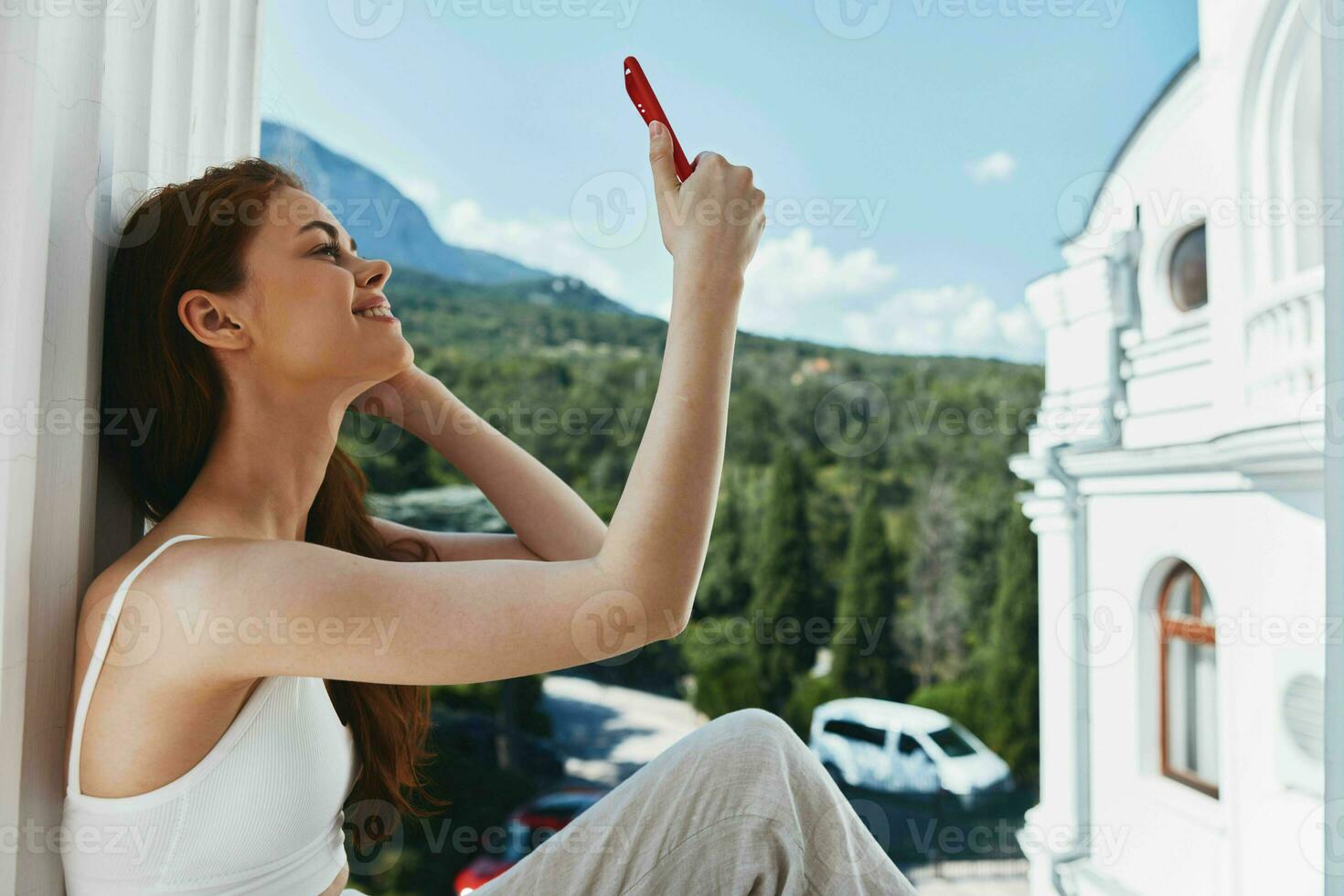 portrait femme avec longue cheveux sur un ouvert balcon vert la nature été journée parfait ensoleillé Matin photo