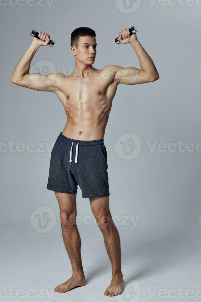 sportif homme en portant haltères dans mains biceps faire des exercices exercice mode de vie photo