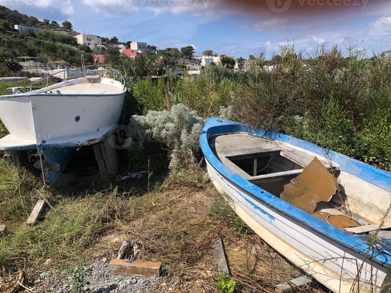 Bateaux de pêche abandonnés et vides en décomposition dans un champ herbeux photo