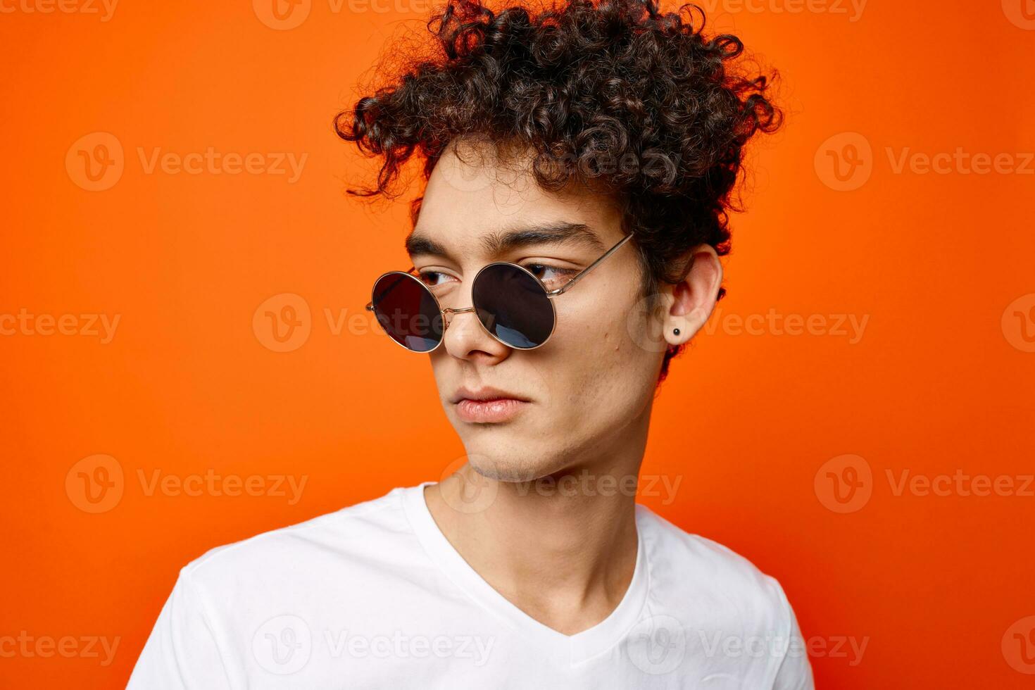 homme dans blanc T-shirt moderne style Orange Contexte des lunettes dans mains photo